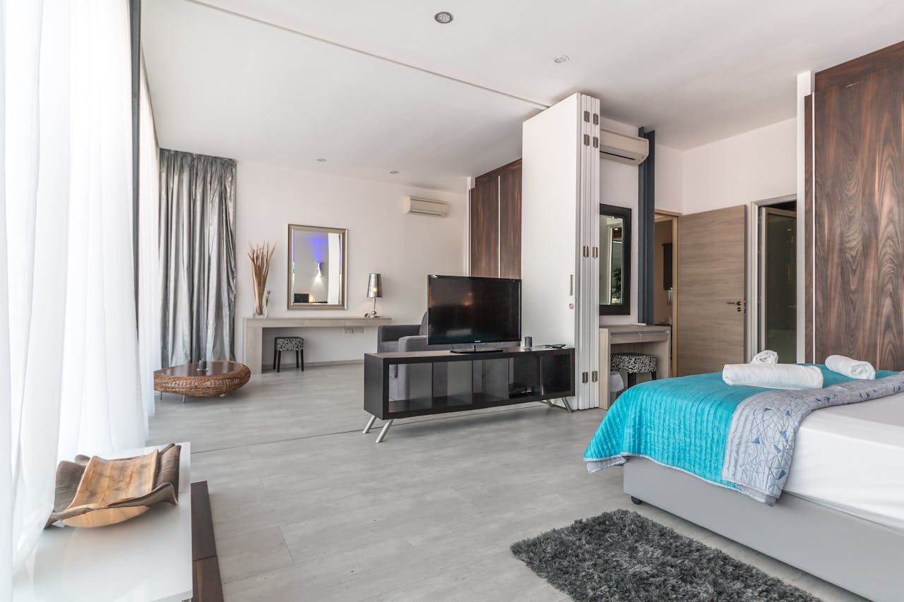 Spacious and modern bedroom with sleek design, featuring elegant decor and natural lighting.